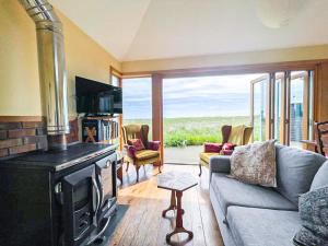 ein Wohnzimmer mit einem Kamin und einem Sofa in der Unterkunft Quirky, Cosy 3BR Cottage With Patio in Canty Bay, Sleeps 10 in North Berwick