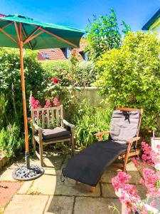 a chair and an umbrella next to a chair and a chair at Quirky, Cosy 3BR Cottage With Patio in Canty Bay, Sleeps 10 in North Berwick