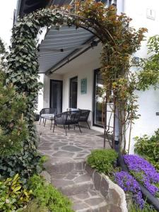 a patio with benches and flowers on a building at Stilvolles Studio im Allgäu in Rettenbach am Auerberg