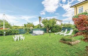 a yard with white chairs and a table and a fence at Casa Katia in Lazise