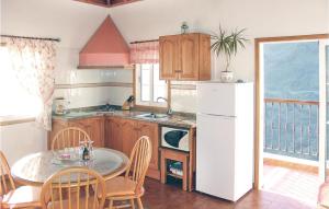 una cucina con tavolo e frigorifero bianco di Casita Acerina Ii a Casa Nueva