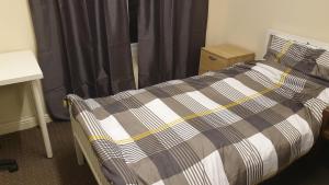 a bedroom with a bed with a black and white blanket at 2 bedroom apartment in Greater Manchester in Ashton under Lyne