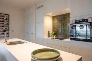 une cuisine blanche avec un évier et une cuisinière dans l'établissement Green h(e)aven, à Nieuport 26 autres photos