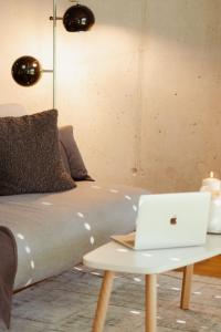 ein Bett und einen Tisch mit einem Laptop darauf in der Unterkunft Loft-Apartment - Bestlage am Kurpark mit Terrasse - kostenloses Parken - Küche - Netflix - Waschmaschine in Wiesbaden
