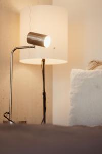 une lampe assise à côté d'un lit avec un oreiller dans l'établissement Loft-Apartment - Bestlage am Kurpark mit Terrasse - kostenloses Parken - Küche - Netflix - Waschmaschine, à Wiesbaden