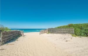 einen Sandstrand mit einem Zaun und dem Meer in der Unterkunft Li Scalitti 1 in Badesi