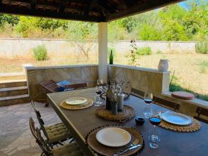 a table with plates and wine glasses on a patio at Casa Mediteran in Stomorska