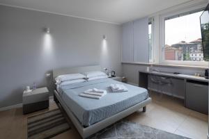 una camera da letto con un letto e asciugamani di Golgi Suite a Pavia