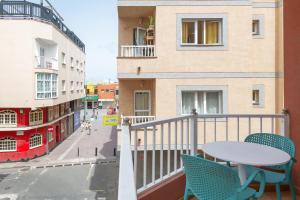 a balcony with a table and chairs on a street at Casa Nadia in Corralejo