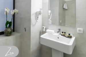 Baño blanco con lavabo y espejo en The Mansion Boutique Hotel, en Bucarest