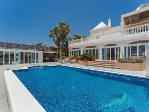 a large swimming pool in front of a house at Gorgeous Golf Villa Heated Pool Sea view in Adeje