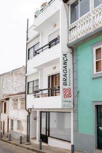 um edifício branco com um sinal na lateral em Bragança Apartments em Brangança
