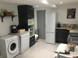uma cozinha com uma máquina de lavar roupa e um frigorífico em Maison de centre ville 6 personnes em Précigné
