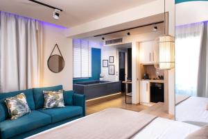 sala de estar con sofá azul y cocina en SKS Luxury Suites & Rooms, en Paralia Katerinis