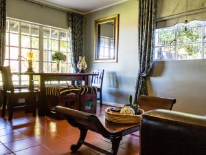 a living room with a table and a dining room at Wellstead Country Manor in Haenertsburg