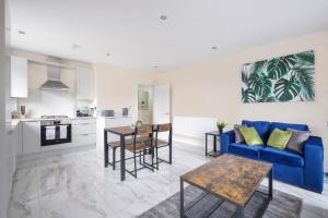 a living room with a blue couch and a table at Oxford Rd 2 Bed Serviced Apartment 06 with Parking, Reading By 360Stays in Reading