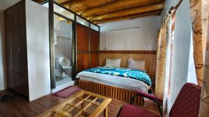 a small bedroom with a bed and a bathroom at Serdung Guest House in Leh