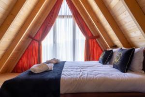 Cama grande en habitación con ventana grande en Batllava Premium Resort Villa 1 en Orllan