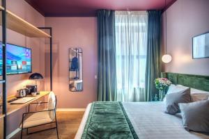 a bedroom with a bed and a desk and a television at Sheva Boutique Hotel in Milan