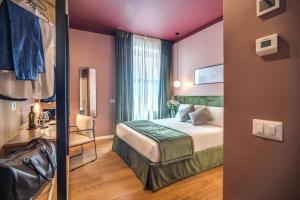 Sheva Boutique Hotel في ميلانو: غرفه فندقيه بسرير ونافذه