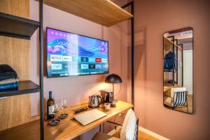 a room with a desk with a laptop and a tv at Sheva Boutique Hotel in Milan