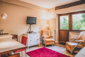 a living room with a tv and a table and chairs at TatryTop Pod Skocznią in Zakopane