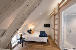 a bedroom with a bed in a attic at Les Clés de La porte Saint-Nicolas - Parking - Centre in Beaune