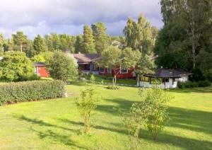 un ampio cortile con una casa sullo sfondo di Private Room in Shared House-Close to University and Hospital-6 a Umeå