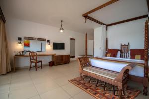 een kamer met een bed, een tafel en een bureau bij Royal Zanzibar Beach Resort in Nungwi