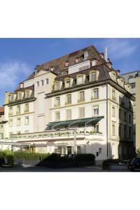 um grande edifício branco com telhado em Hotel Weißes Kreuz em Bregenz