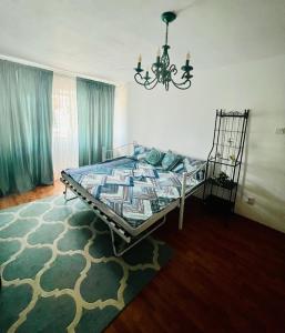 a bedroom with a bed and a chandelier at By The Sea for Family in Mangalia