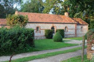 an old brick house with a green yard at The Engine House in East Dereham