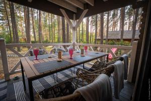 a table on a porch with red glasses on it at Domek rekreacyjny DORAN in Tuczno