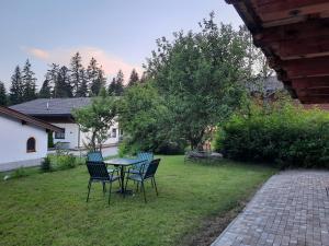 a patio with a table and chairs in a yard at Ferienwohnung Erhart Scheffau in Scheffau am Wilden Kaiser