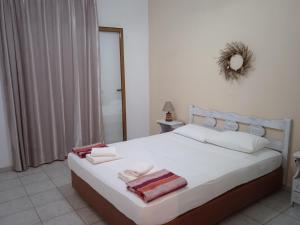 a bedroom with a white bed with towels on it at Skoutari Beach Hotel in Skoutari +78 photos