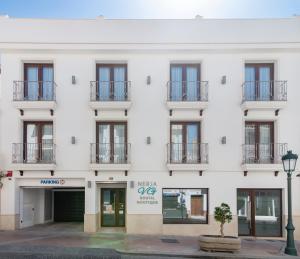 a white building with windows and balconies at Nerja VG Hostal Boutique in Nerja