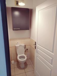 - une petite salle de bains avec des toilettes et une porte dans l'établissement Le Saint B Leu 3 nuits minimum, à Saint-Leu