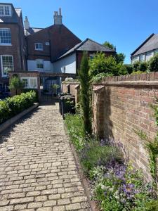 a brick walkway in a yard with houses at Central Location - Riverside - Cosey Cottage - Close to Beaches in Christchurch
