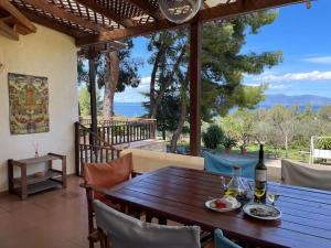 una mesa de madera con una botella de vino en el patio en Stunning Evia Sea View Country House, en Roïdhítsa