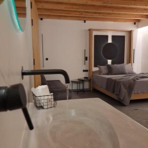 Nisaki Hotel & Elite Suites في إرموبولّي: غرفة بسرير وطاولة مع ماء