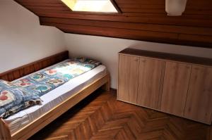 a bedroom with a bed and a wooden cabinet at Váralja Vendégház Tihany in Tihany