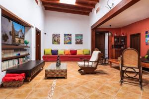 a living room with a red couch with colorful pillows at Histórica Villa con molino de viento in Antigua