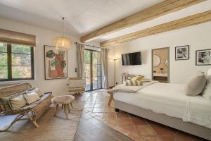 a bedroom with a large bed and a couch at Domaine des Chênes de la Galline in La Garde-Freinet