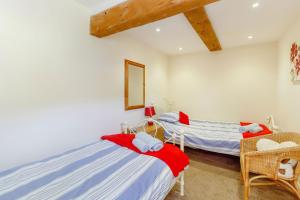 two twin beds in a room with white walls at Jim's Barn in Diggle