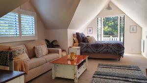 uma sala de estar com um sofá e uma cama em Mountain Studio Escape em Mount Tamborine