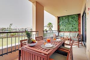 a wooden table on a balcony with a table and chairs at Andiamo Apartment in Vilamoura