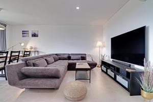 a living room with a large couch and a flat screen tv at Andiamo Apartment in Vilamoura