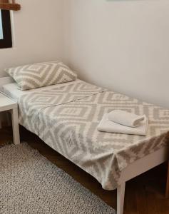 a bed with two towels sitting on top of it at Apartments Dora in Pag