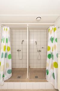 a bathroom with two showers and a shower curtain at MP Hostel Budapest in Budapest
