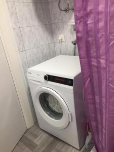 梅杜林Double room with bathroom, WiFi, airco, parking, washing machine, grill的浴室内配有一台洗衣机和紫色窗帘